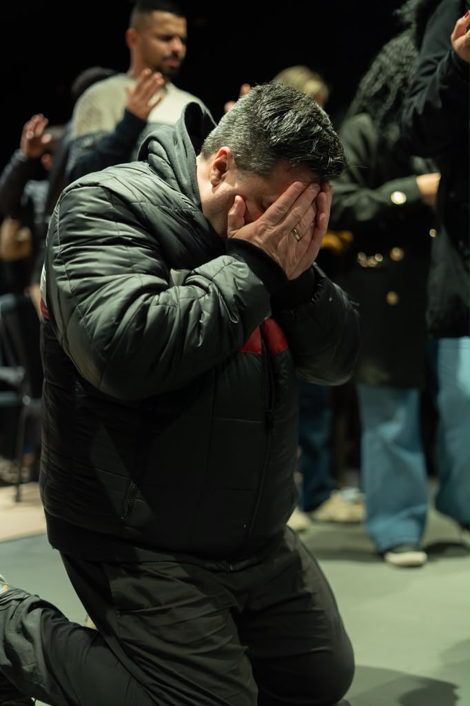 Homem ajoelhado em oração durante o culto